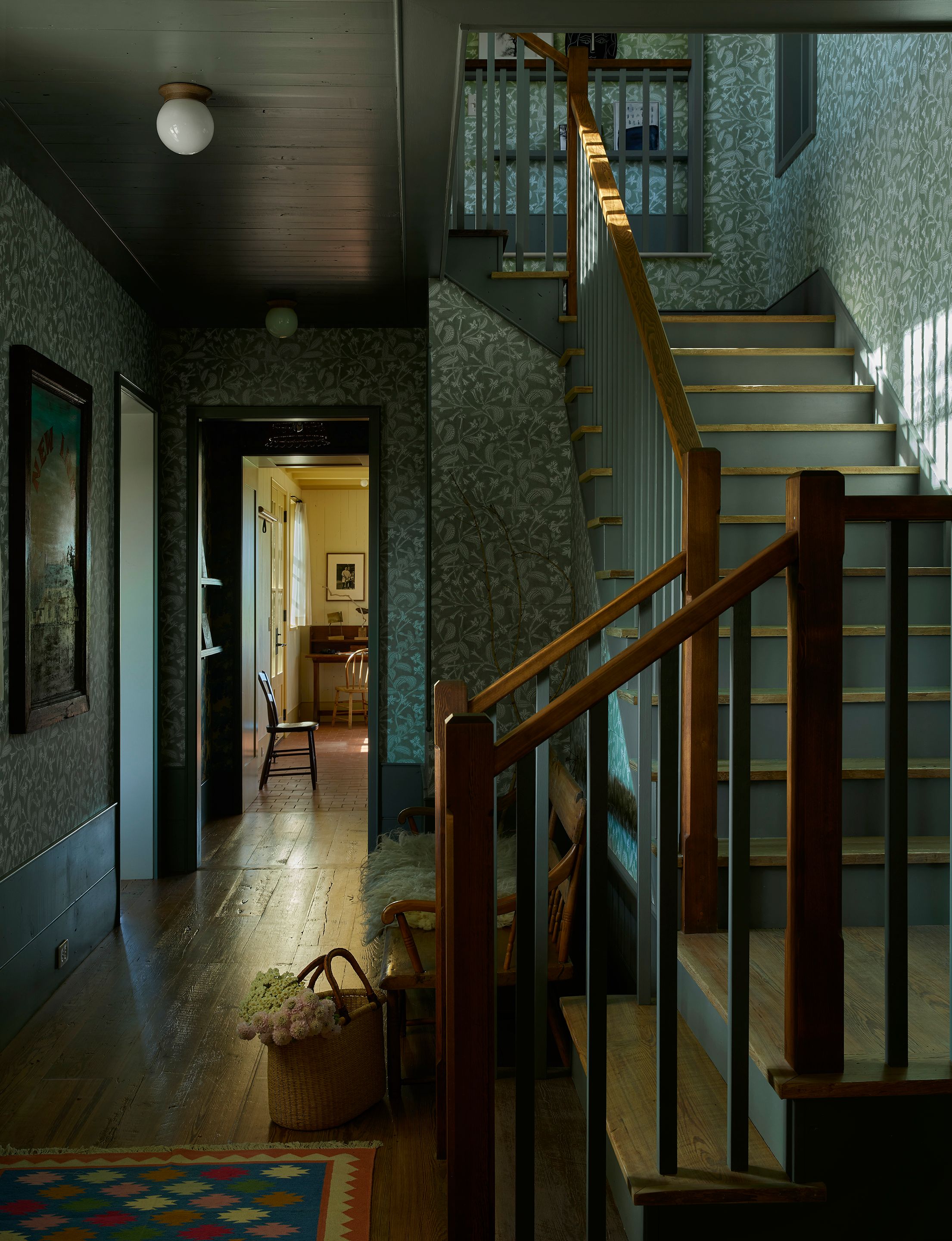 Wrapped in Marthe Armitage’s Tobacco Plant in Farrow & Ball Lichen wallpaper, the entry to the farmhouse is a lush, leafy retreat from the Colorado elements that range from high heat in the summer to heavy snow in the winter. An antique train depot bench sits next to the stairwell across from a framed vintage English pub sign that reads “New Inn.” A cotton Dhurrie rug from Sahjad Carpets adds bright, crisp geometry.