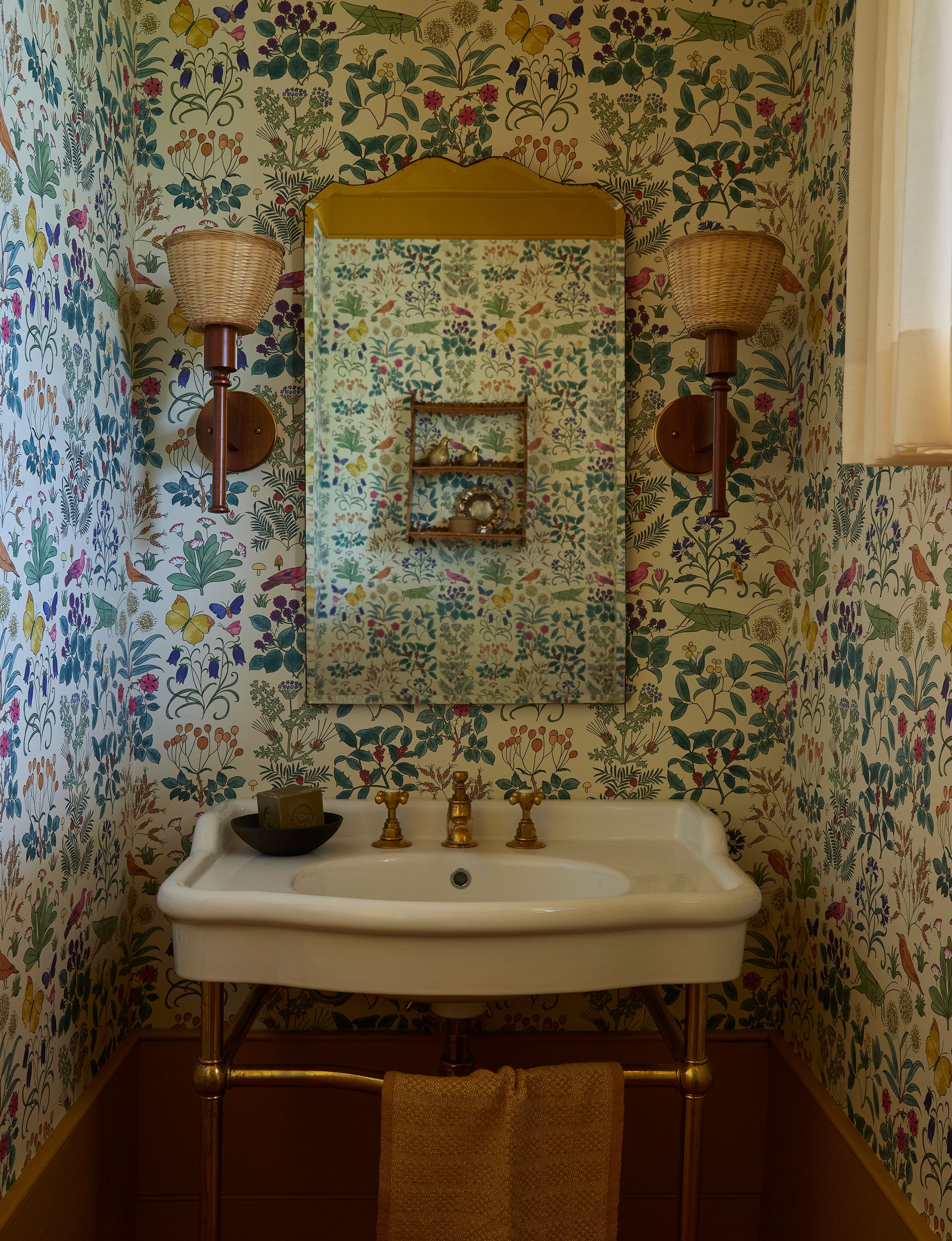 In the powder room, the Charles Voysey’s Apothecary’s Garden wallpaper has the first and last word. The mirror is vintage from the ’50s and the sconces are vintage Uno Kristiansson from the ’60s. The sink is a medium Paris basin on a brass frame by Water Monopoly.