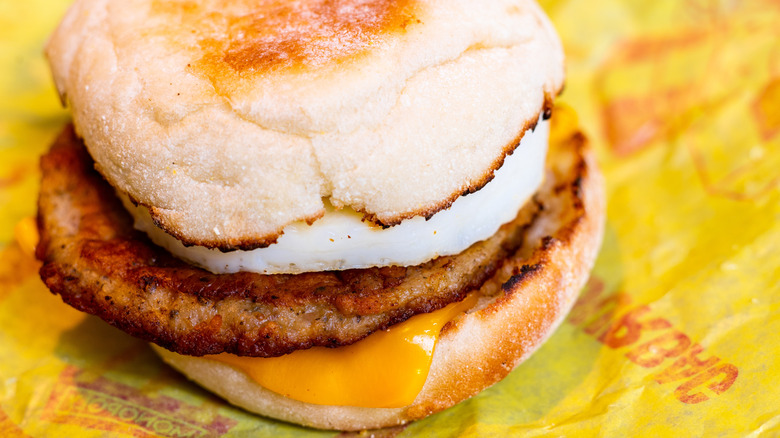 A Sausage and Egg McMuffin on a yellow McDonald's wrapper