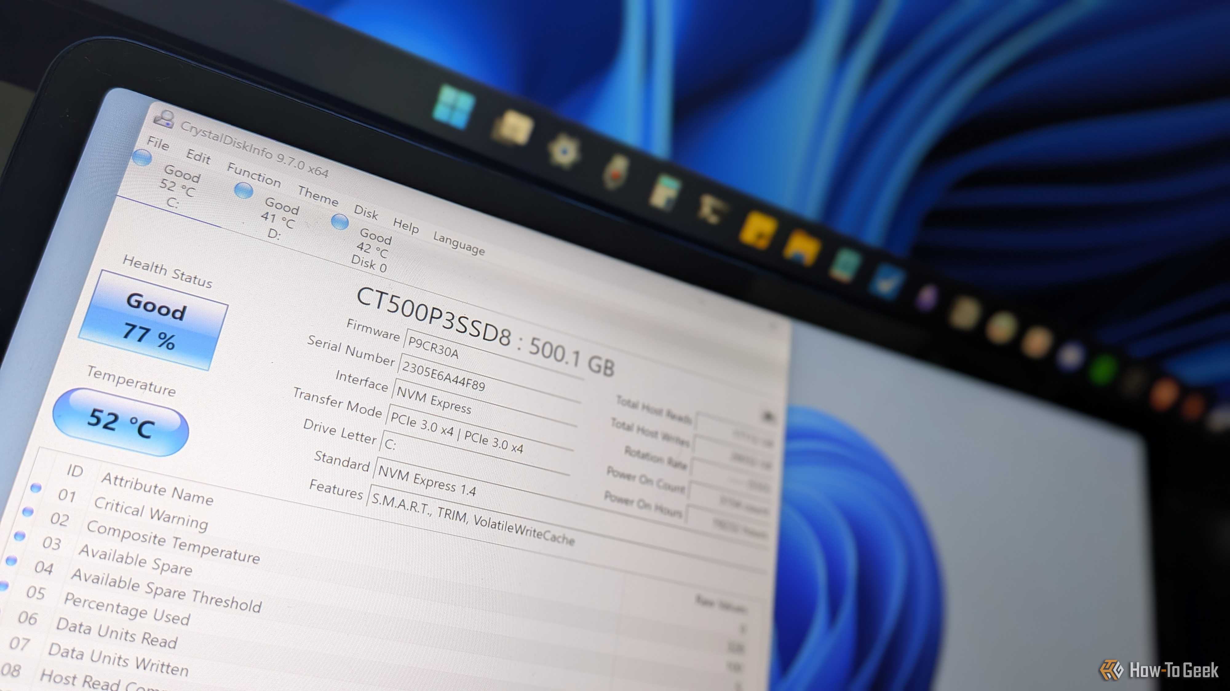 Real-world photo of a monitor displaying CrystalDiskInfo with CT500P3SSD8 showing Good 77 percent health.