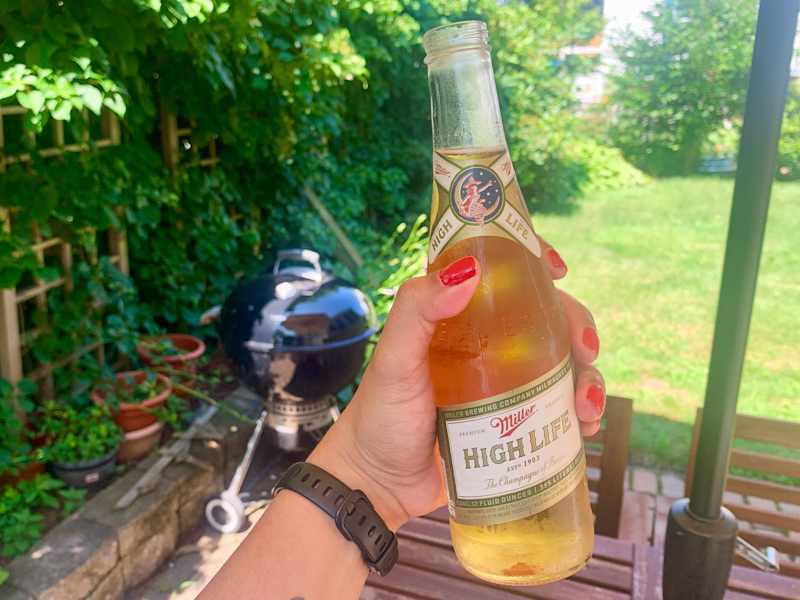 Someone holding bottle of Miller High Life.