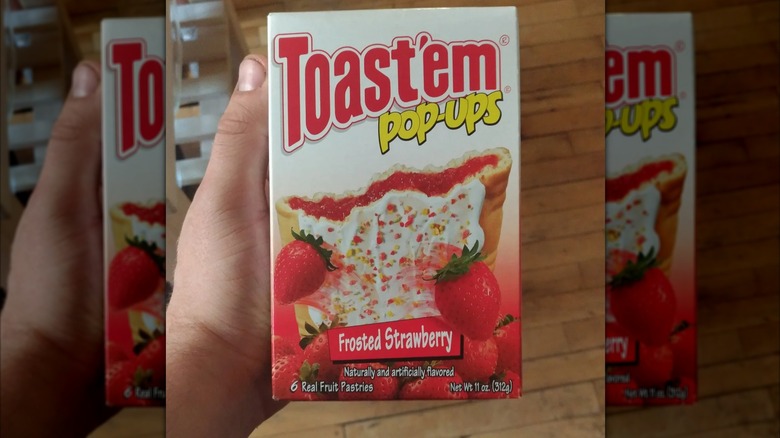 A hand holds a box of Frosted Strawberry Toast'em Pop-Ups.