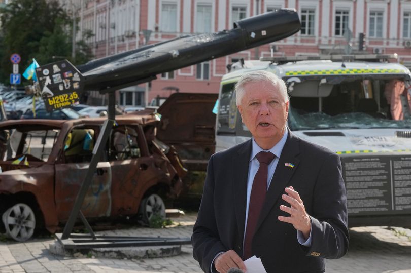 Lindsey Graham answer media questions near a damaged Russian vehicles exhibition in central Kyiv