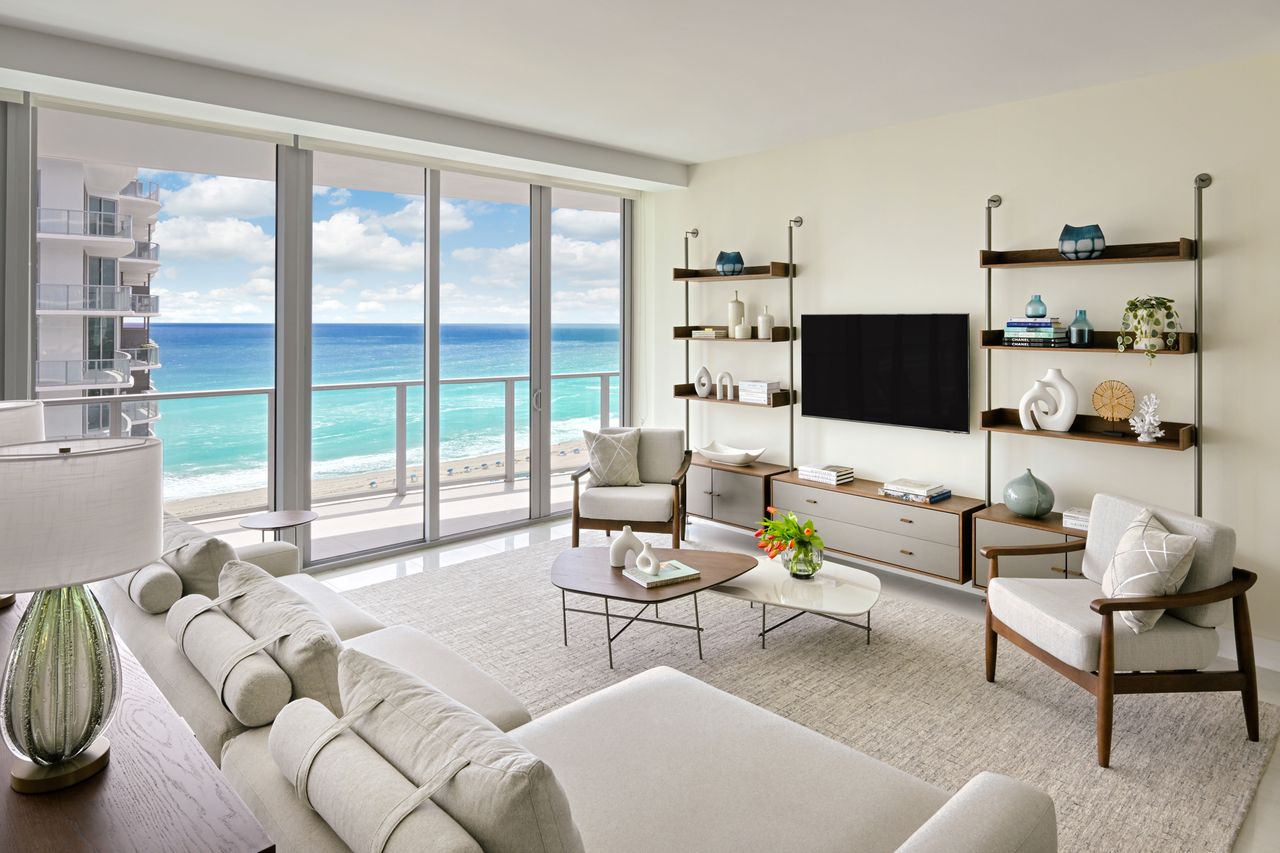 Luxury beachfront living room with large windows and modern furnishings
