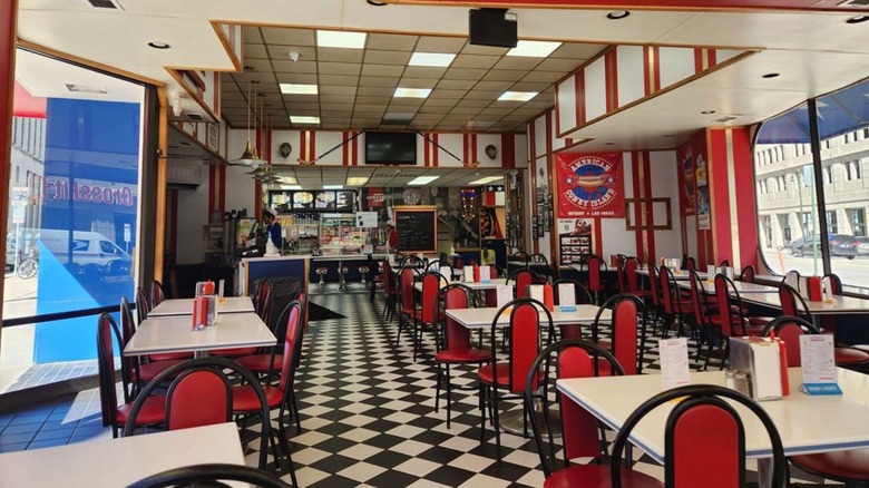 Empty interior of American Coney with white tables and red chairs