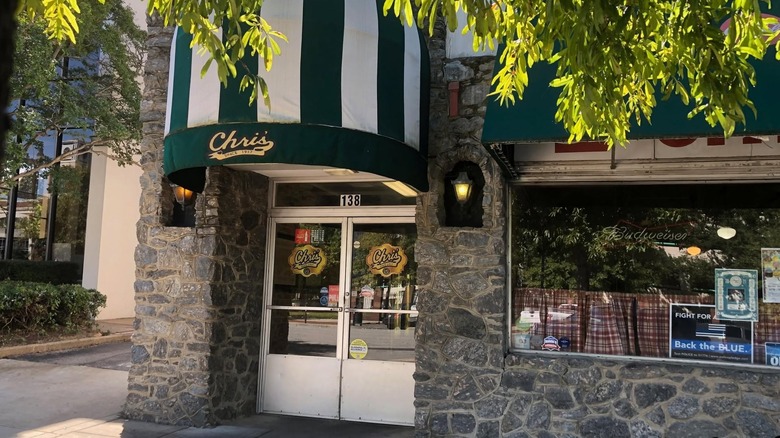Exterior of Chris's stone building with white and green awning