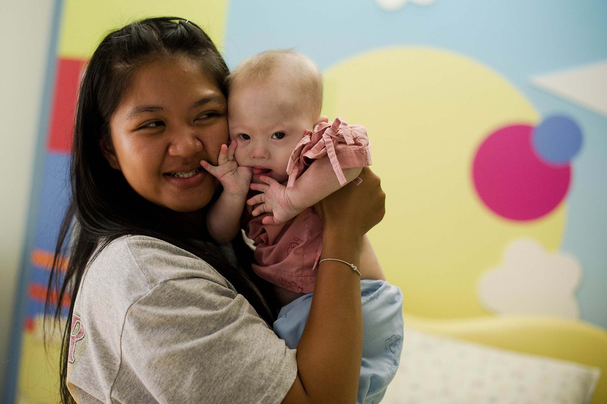 Thai surrogate mother Pattaramon Chanbua holds her baby Gammy, born with Down's syndrome, at a hospital in Chonburi province in 2014. Photo: AFP