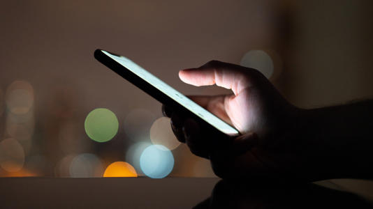 A person using a phone in the evening