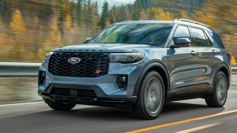 Front three-quarter view of gray Ford Explorer ST on forest highway.