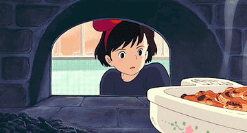 Animated character, a young girl with a bow in her hair, looks at food cooking inside an oven