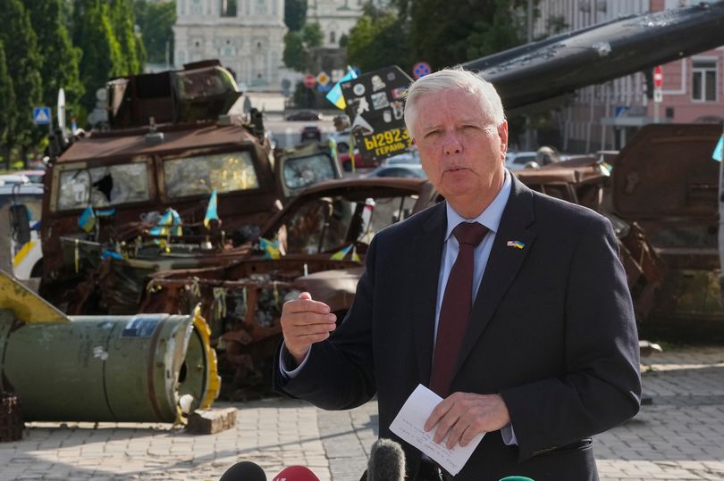 Lindsey Graham answer media questions near a damaged Russian vehicles exhibition in central Kyiv