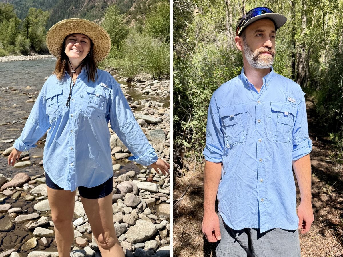 Two people wear light blue Columbia button-up shirts outdoors beside a river and in a wooded area.