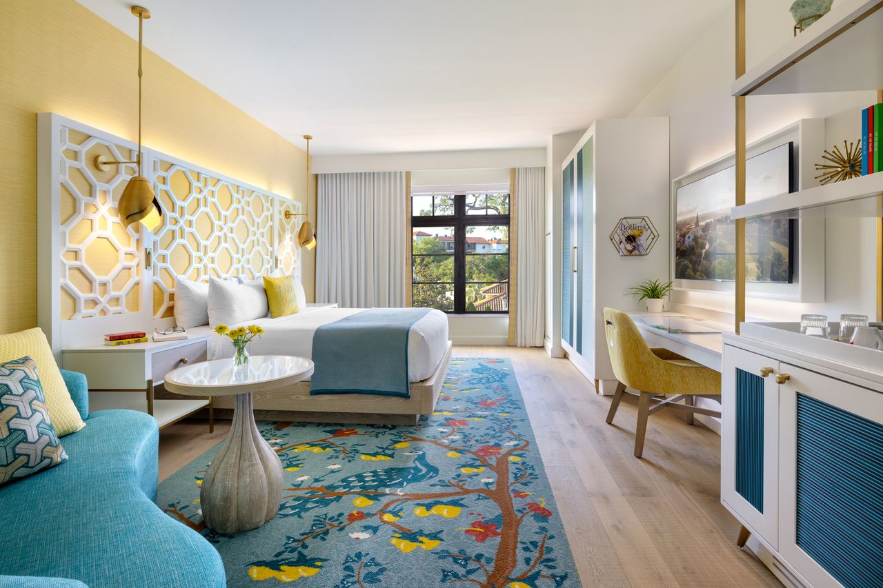 Hotel guest room with a bed a seating area and decor showcasing a large window and workspace