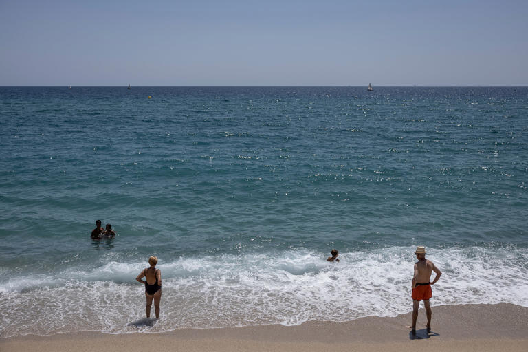 Socorristas vigilan a bañistas en la playa de Badalona en foto de archivo.