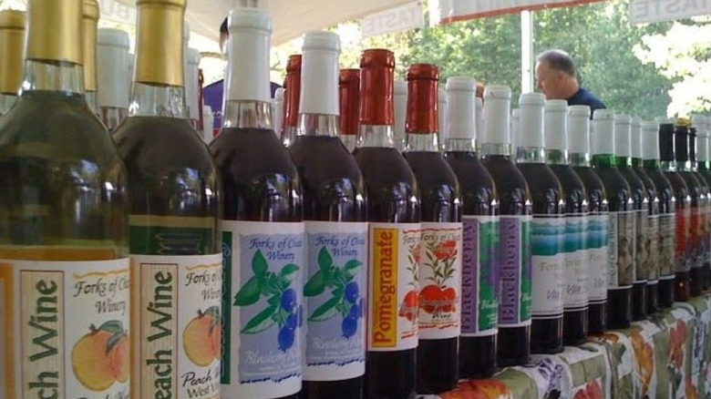 Row of Forks of Cheat wines on a colorfully-clothed table, with peach, blueberry, pomegranate and blackberry wines dominating the foreground.