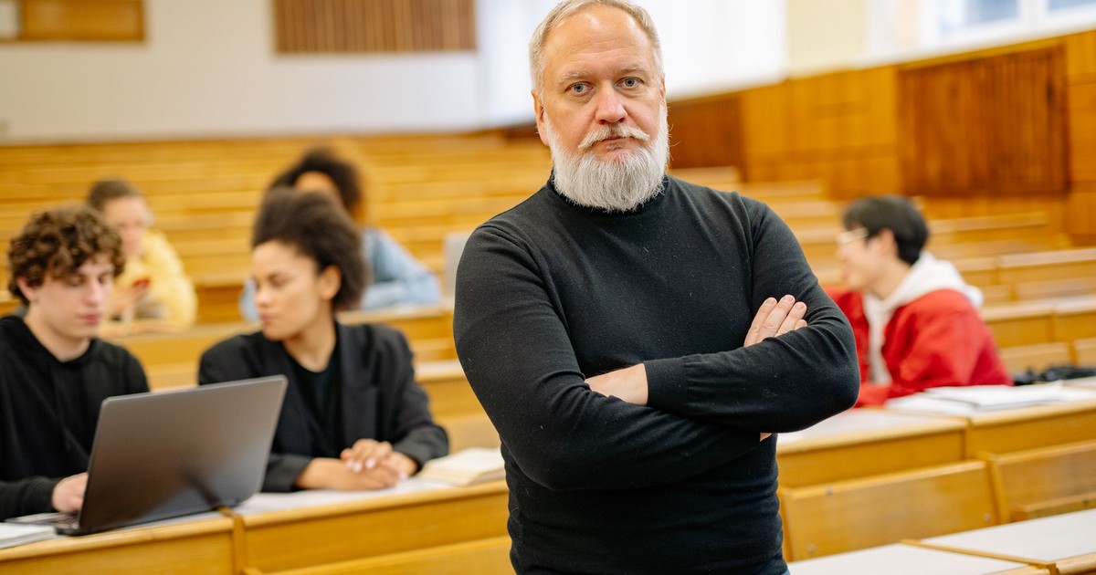 Confident professor in lecture hall with diverse students engaged in learning.