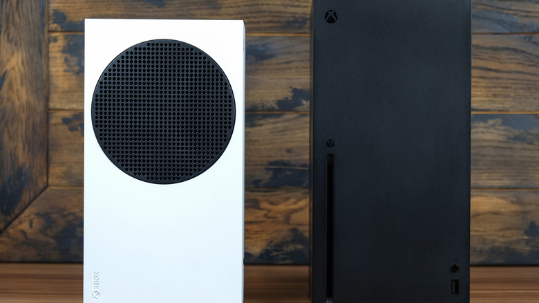 Xbox Series S and Xbox Series X consoles next to each other while standing up on a surface