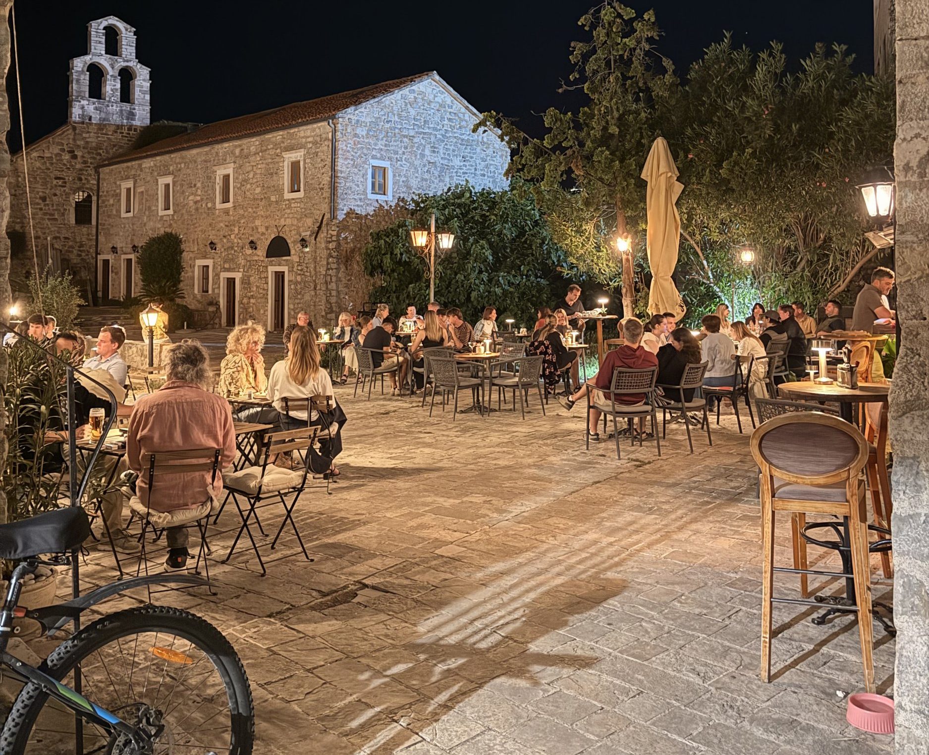 The Blue Cat bar hidden down an alleyway in Budva, showing a lit up courtyard
