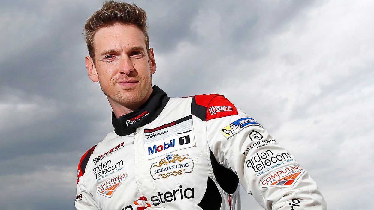 Paul Rees in racing car outfit - white, red and black all-in-one