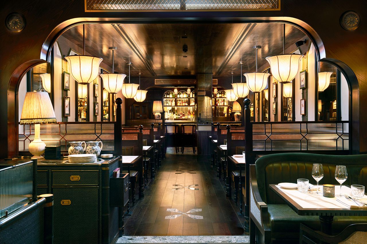 Interior of a restaurant with tables on both sides and light fixtures hanging from the ceiling