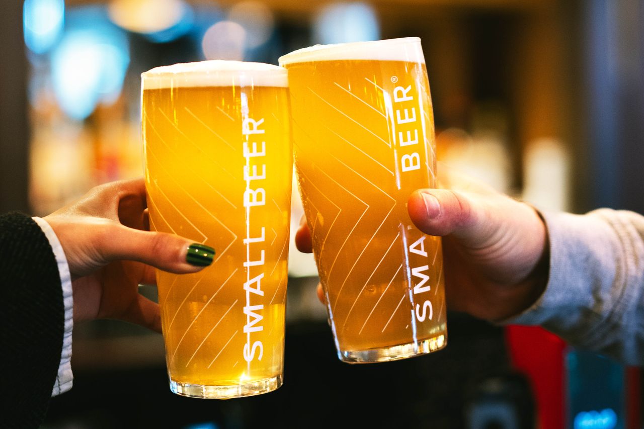 Two people toasting with glasses of Small Beer