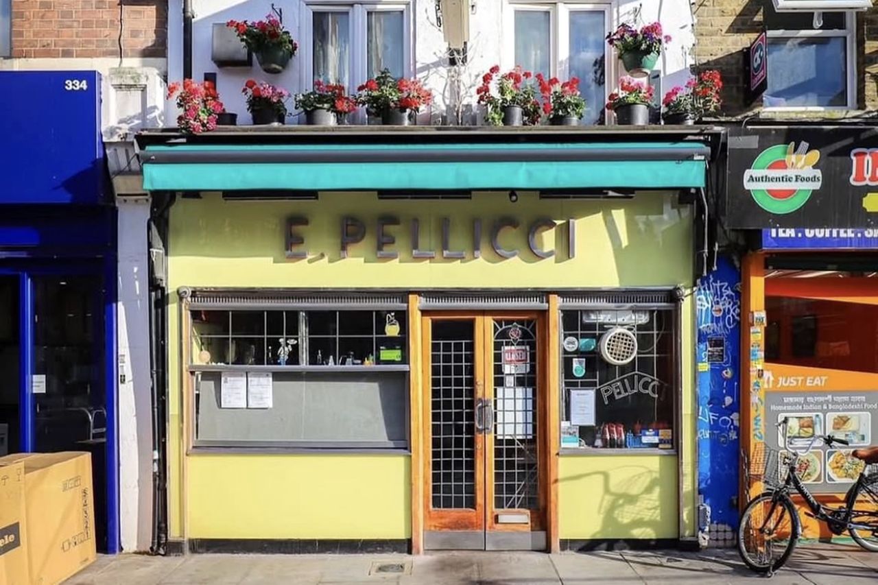Exterior view of E Pellicci a restaurant in a city street with flowers decorating its facade