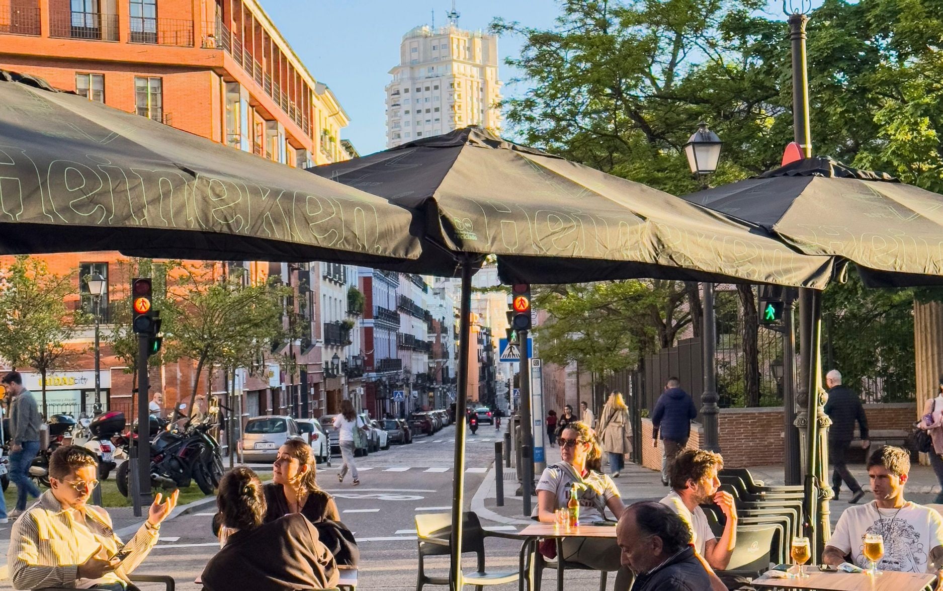 Terrace with beer people in Calle Conde Duque and the Torre de Madrid, Madrid , Spain