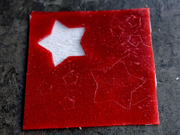 Overhead view of strawberry fruit roll-up being cut into star shapes.