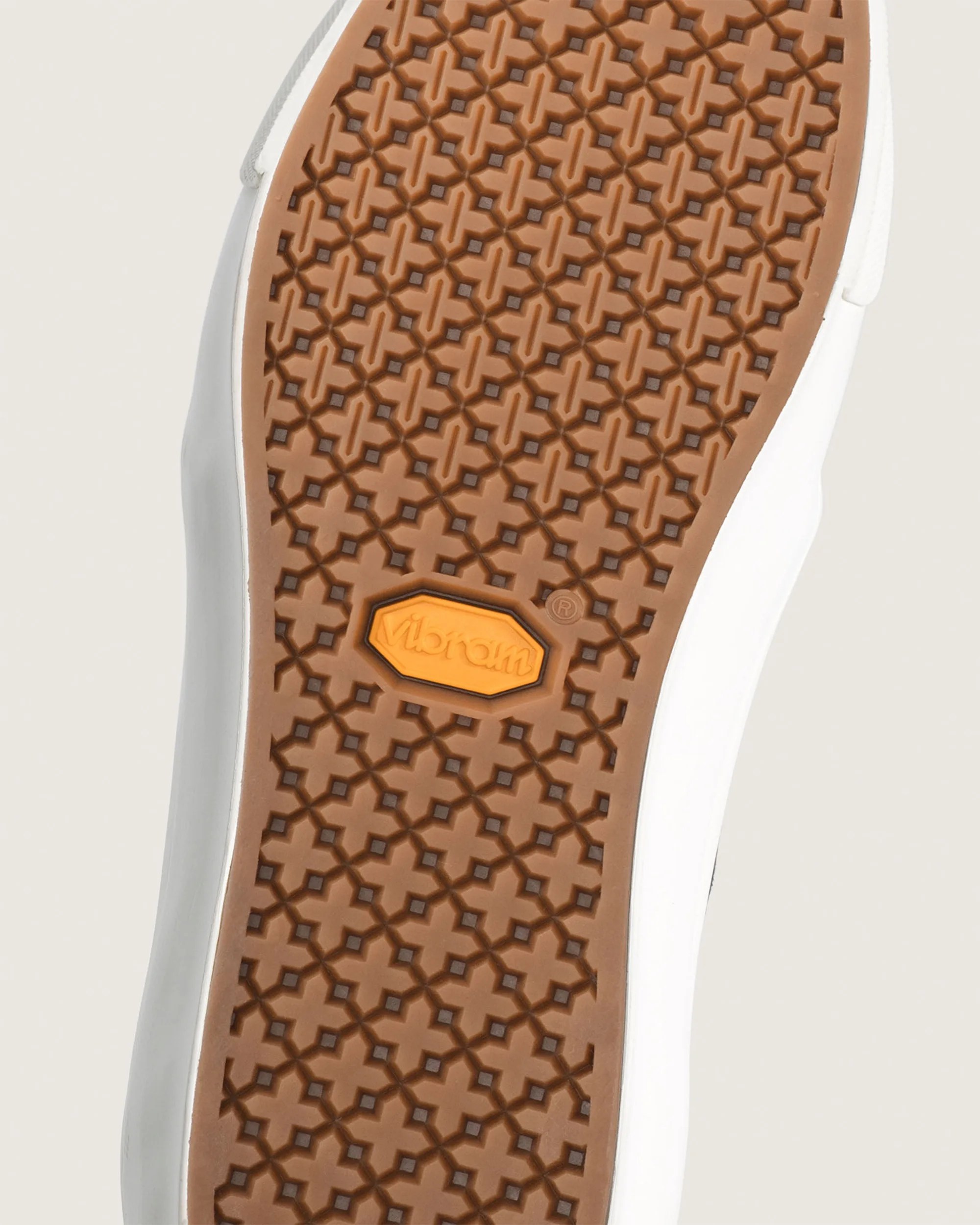 Brown rubber shoe sole with a geometric cross pattern and an orange Vibram logo.