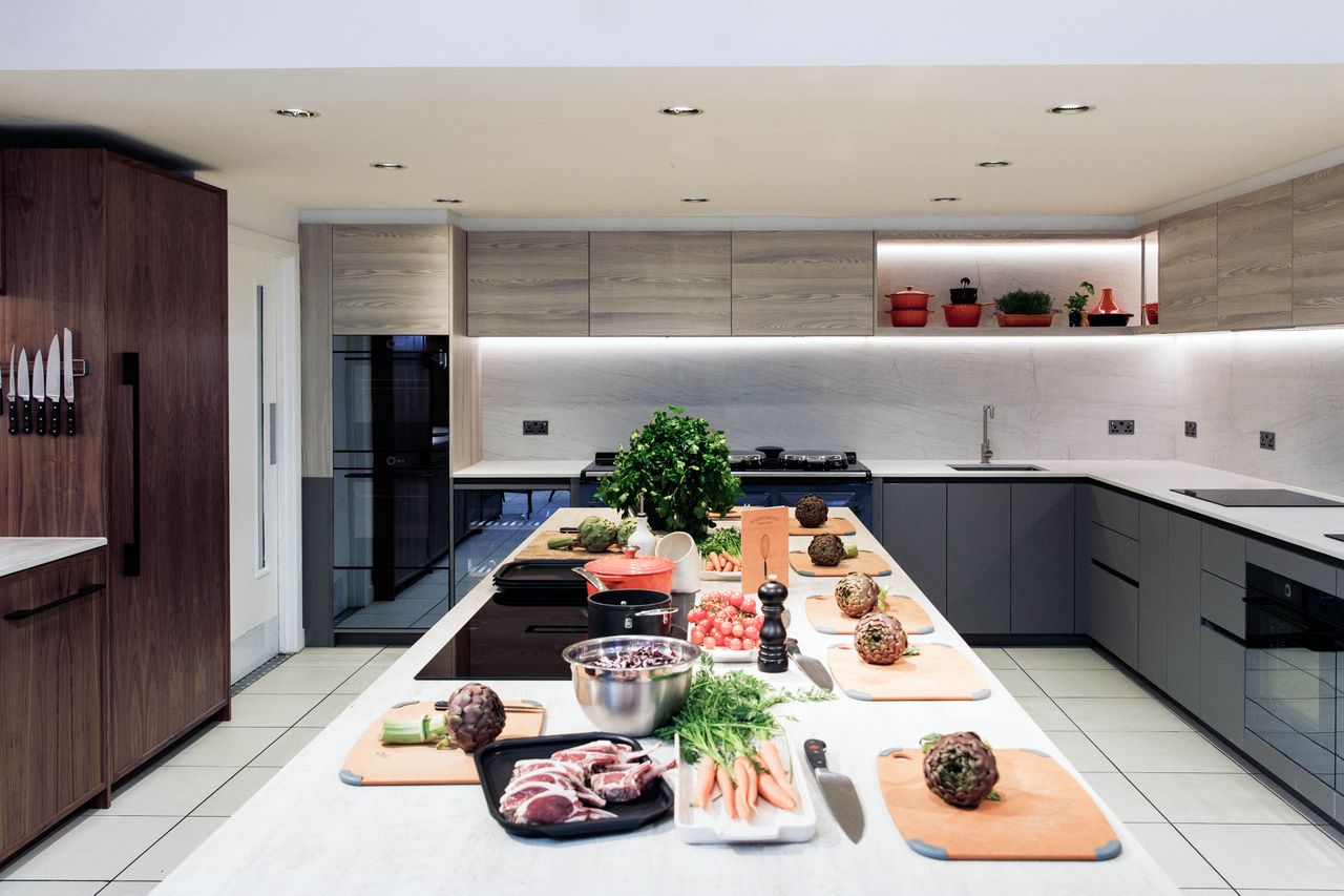 A cooking classroom with a modern kitchen setup featuring preparation materials ingredients and utensils on counters