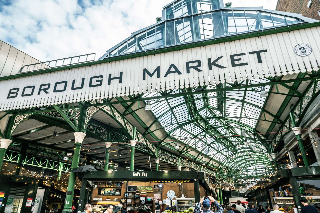 The entrance of Borough Market with its signage and people walking in the market area