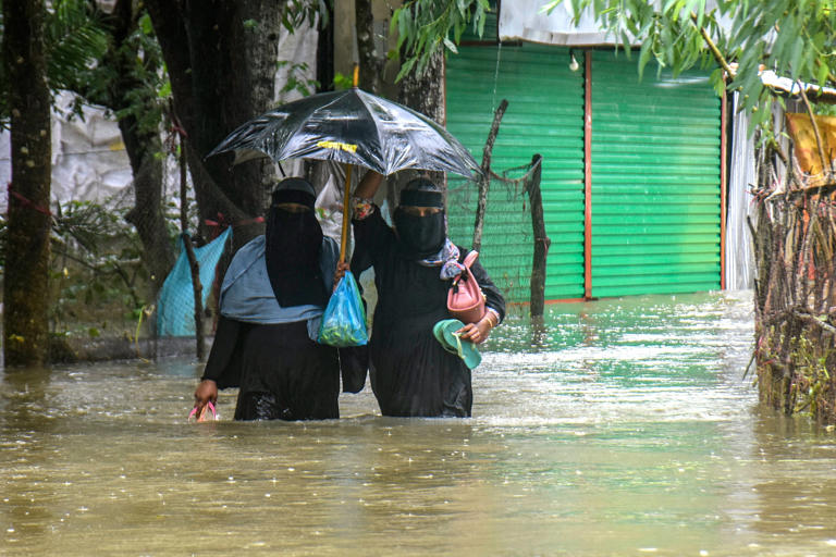 Residents wade through floodwaters after heavy monsoon rains in Chattogram (AFP/Getty)