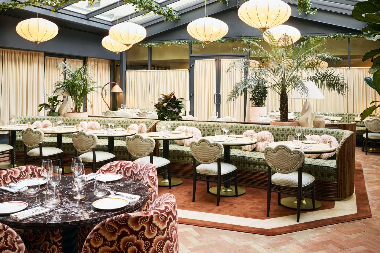 Dining area with light fixtures tables and chairs in a welldecorated room with a natural theme