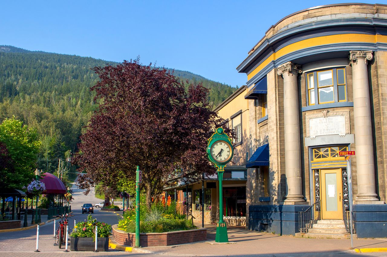A street in downtown Revelstoke British Columbia with a clock and a historic building
