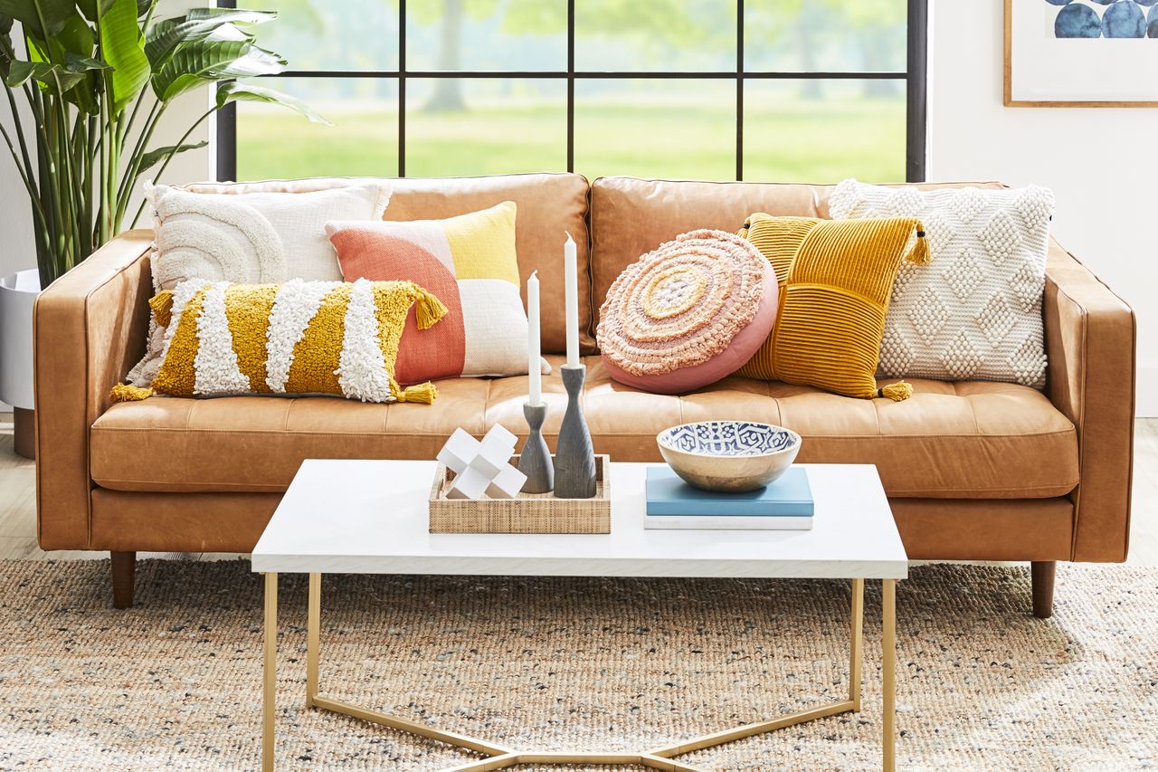 Vibrant throw pillows mixed and matched on a leather sofa