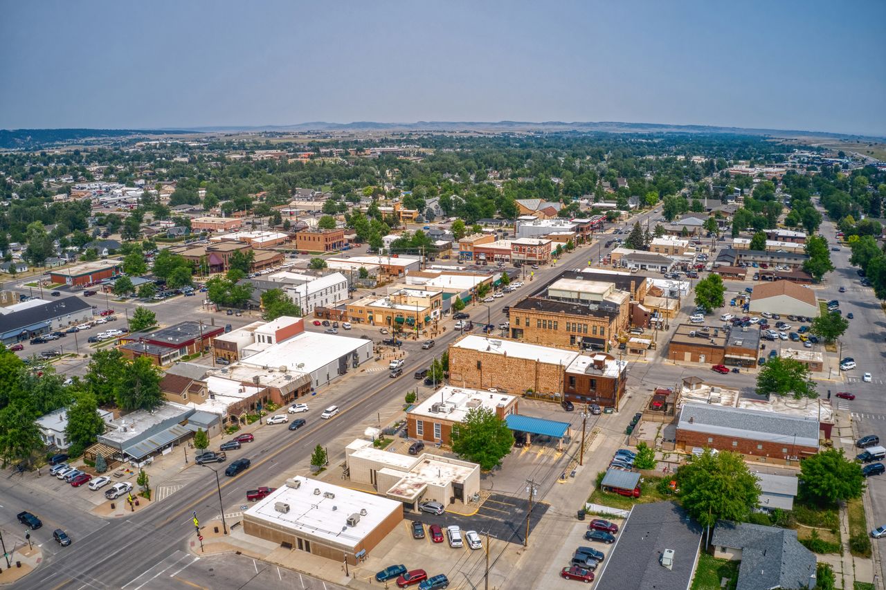 An aerial view of a small city with buildings streets and trees capturing a local community layout