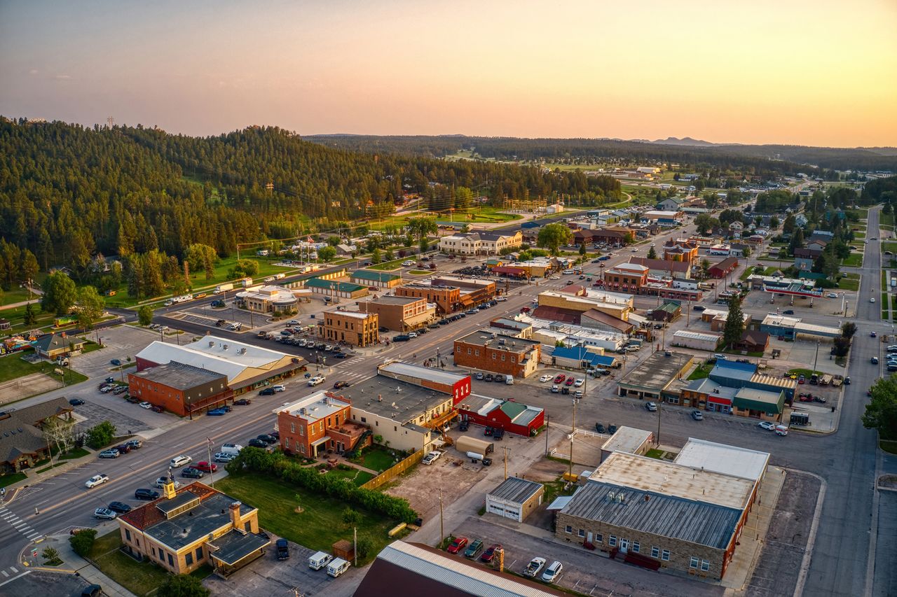 Aerial view of a small town surrounded by trees showing streets and buildings in a rural setting
