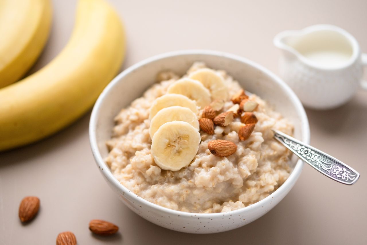 Bowl of oatmeal topped with banana slices and nuts