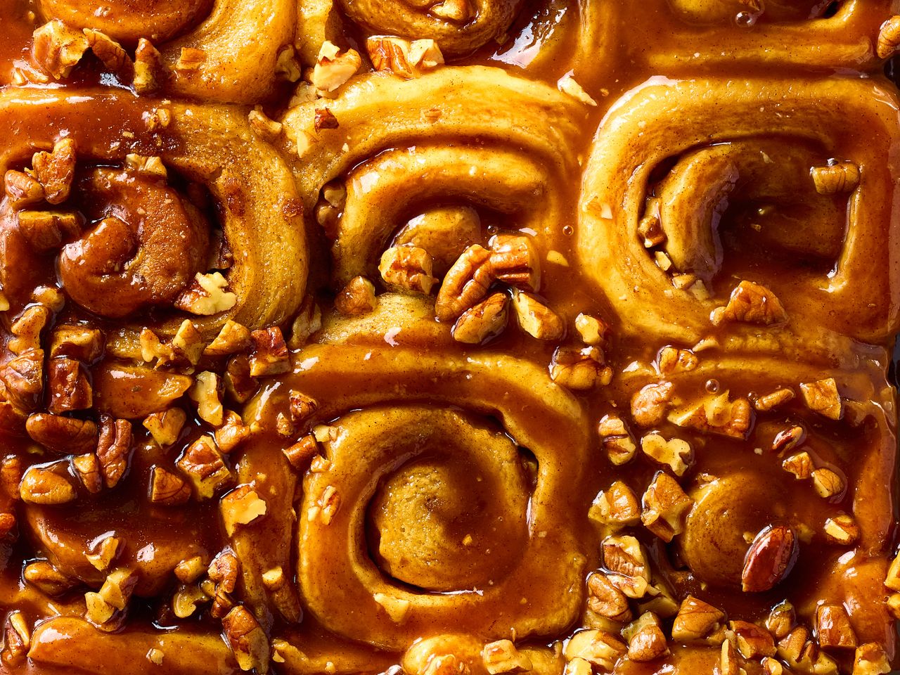 Close-up of ooey-gooey cinnamon buns topped with pecans