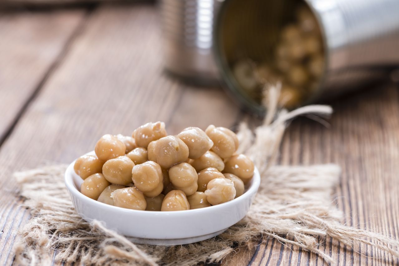 Portion of chickpeas in a small dish on wooden table