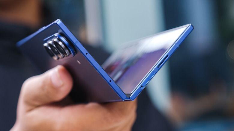 A person holding the Samsung Galaxy Fold7 smartphone half-folded in their hand
