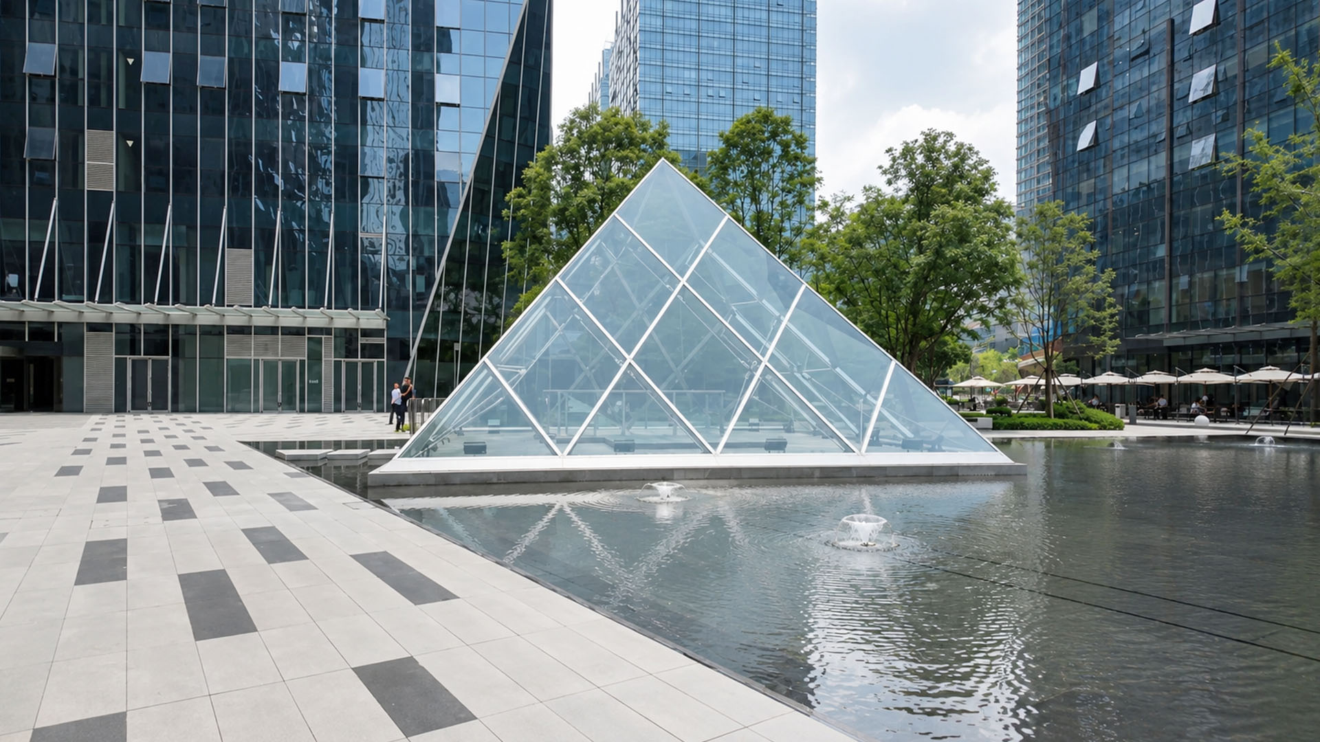 This contemporary plaza features a glass pyramid surrounded by ...