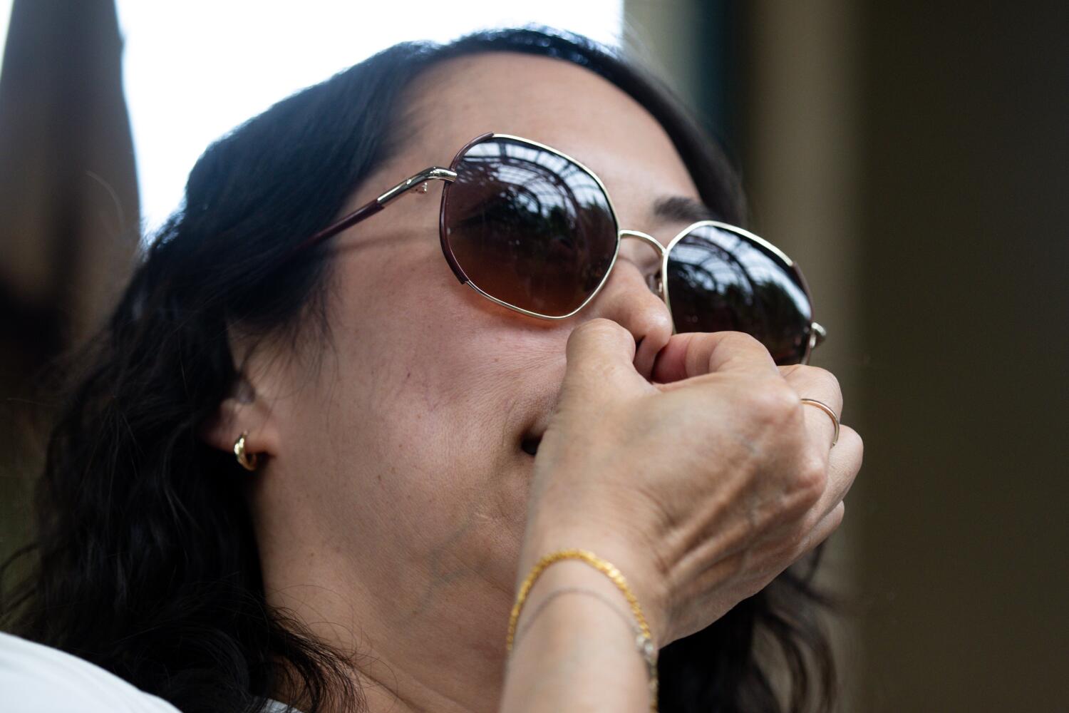 Jaime Holmes from San Gabriel holds her nose in front of the blooming corpse flowers.