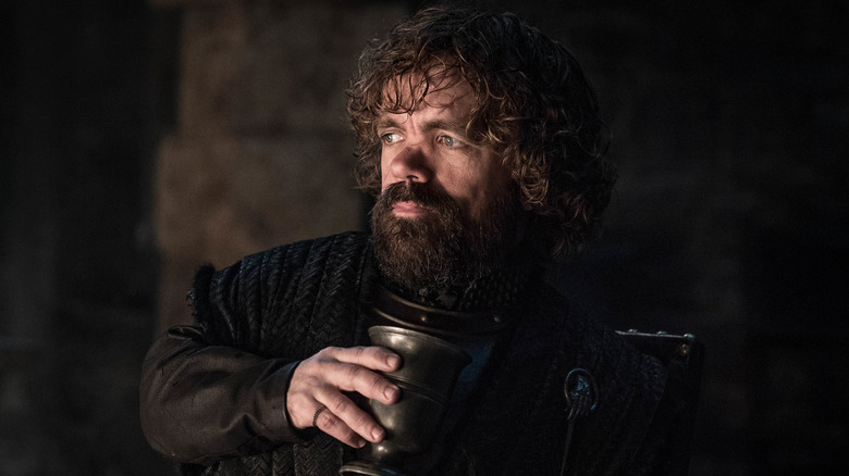 Tyrion holding a goblet in front of a fire on Game of Thrones