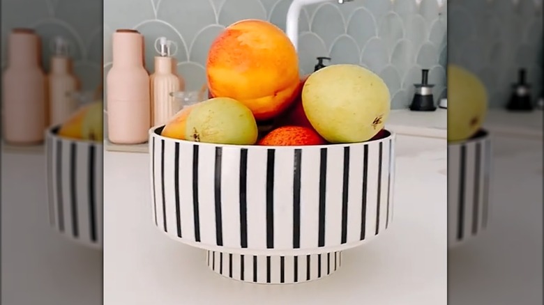 Fresh fruit on white modern chic countertop in striped pet bowls repurposed as stylish fruit bowl