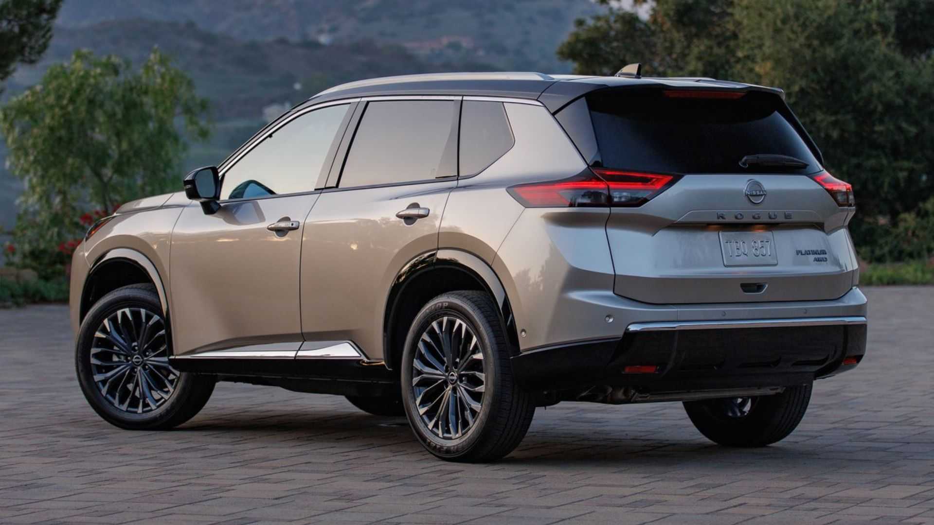 Static rear 3/4 shot of a gold 2024 Nissan Rogue.