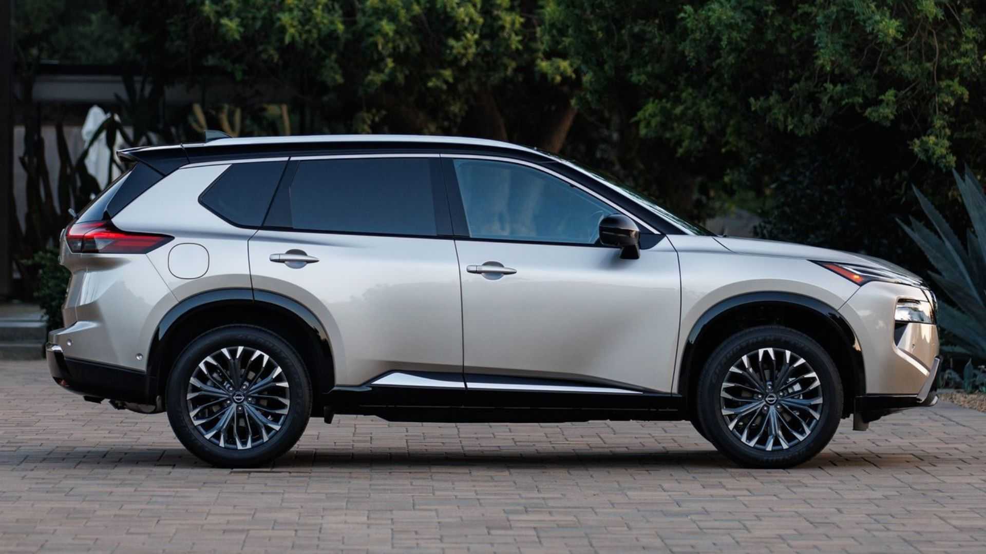 Static side profile shot of a gold 2024 Nissan Rogue.