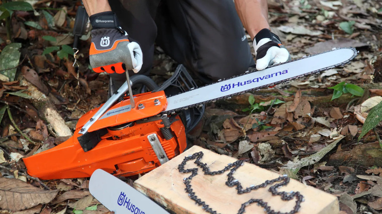A man reparing his Husqvarna chainsaw