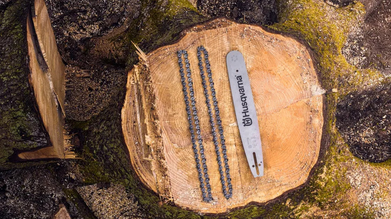 Husqvarna saw chains and guide bar on a tree stump