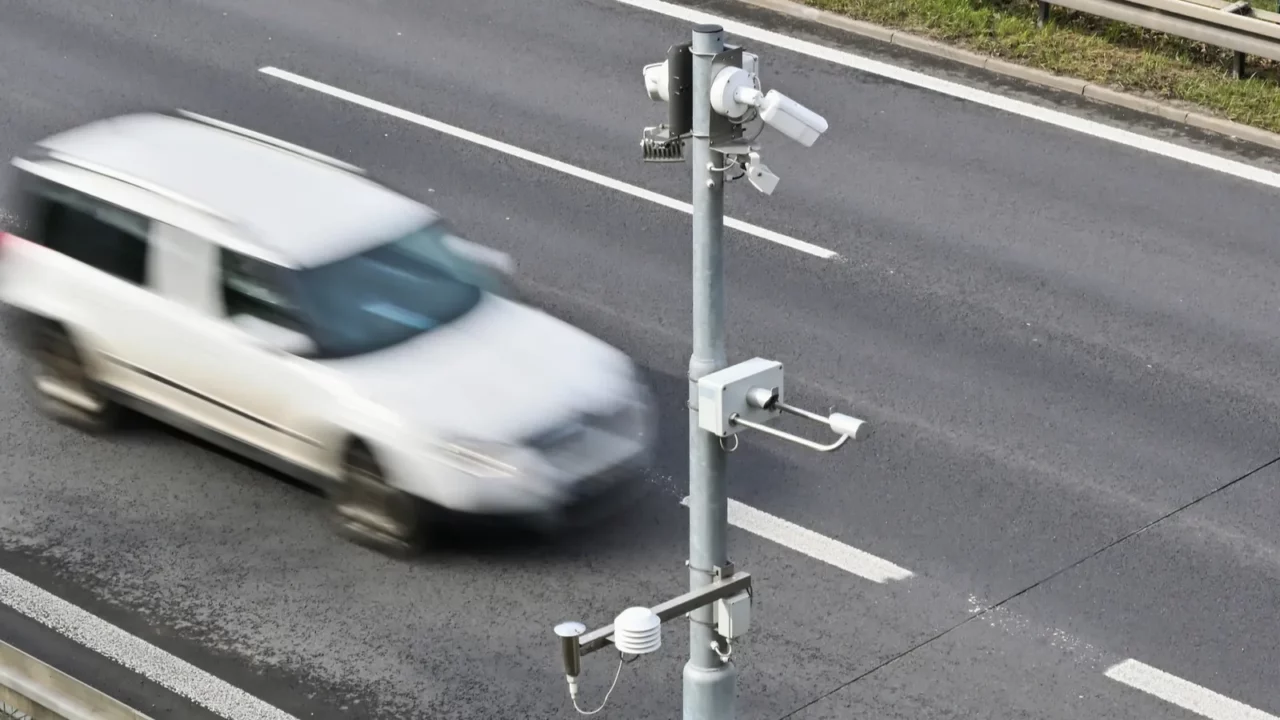 traffic surveillance camera with white car in the background